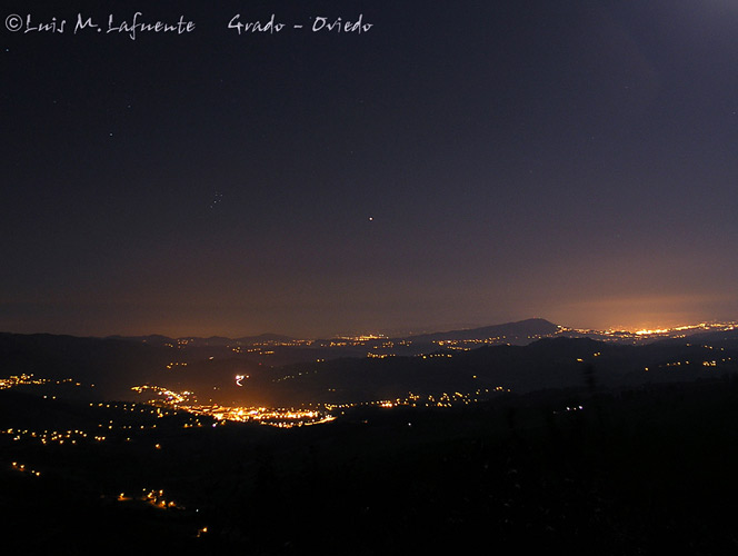 Nocturno de Grado y Oviedo, la agrupación de estrellas de la izquierda es conocida como las pleiades y el punto luminoso en el centro de la imagen es el planeta Marte